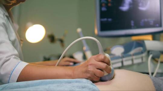 医生在检查孕妇时使用超声波设备