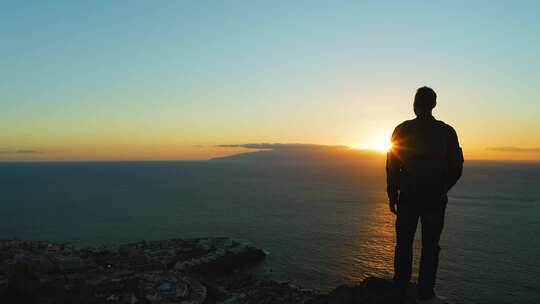 站在山顶的人夕阳下的剪影