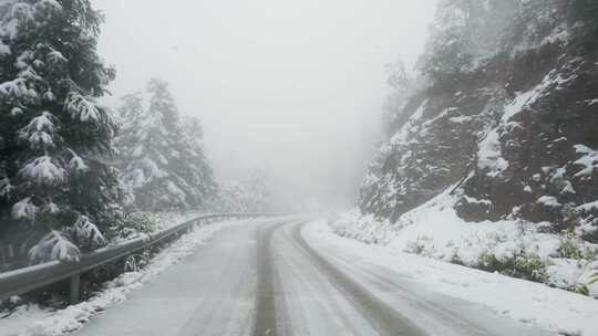 行车第一视角：雪花纷飞的山间公路行驶风景