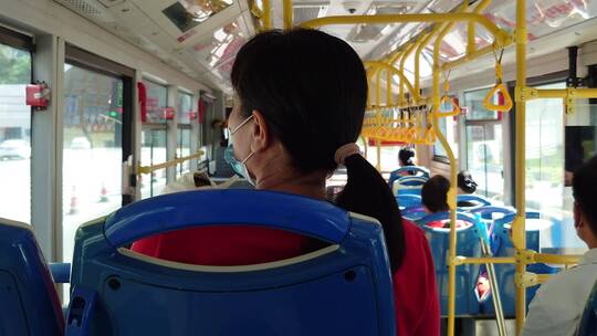 行驶在公交车上妇女的背影