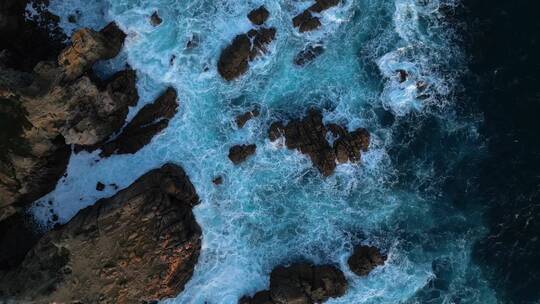 航拍海浪花冲击岩石海边清澈的海水