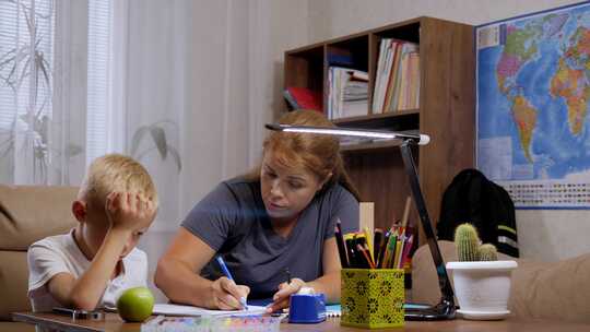 一位愤怒的母亲责骂她的儿子在家庭作业中犯了一个错误