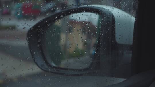 透过布满雨滴的车窗看外面的后视镜