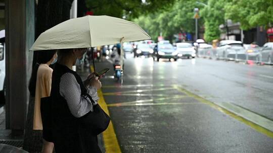 雨天美女打伞玩手机等公交车视频素材模板下载