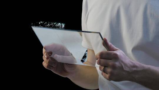 一名男子手持并使用一块未来派的平板电脑