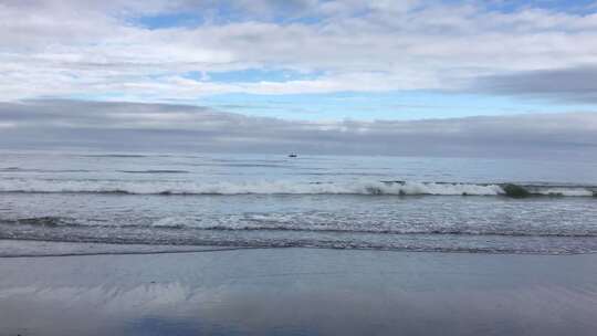 海滩海浪与海上小船景象