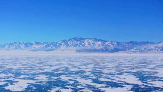 航拍新疆冬季赛里木湖冰封湖面雪山冰湖积雪