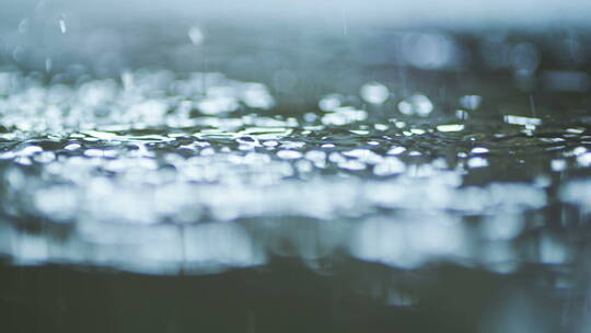 豆大的雨滴落在水坑里视频素材模板下载