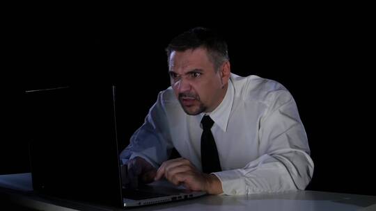 男人坐在笔记本电脑前情绪激动