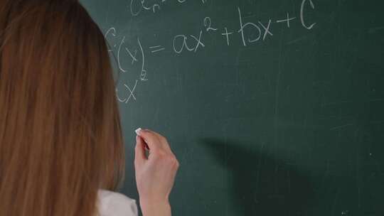 一个女学生用粉笔在黑板上写数学公式视频素材模板下载