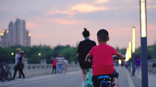 夕阳下公园游客骑自行车视频素材模板下载
