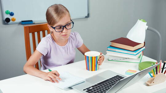 女孩在书桌前用电脑学习