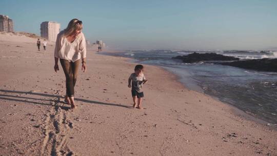母亲带孩子在海边散步