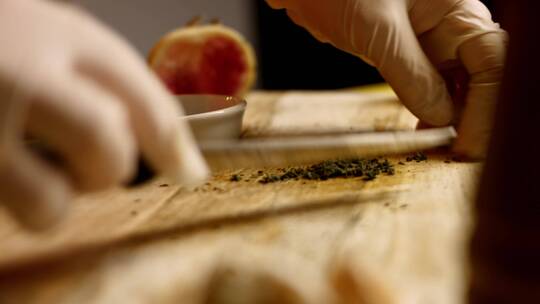 厨师在木板上准备切碎的绿色香草和大蒜