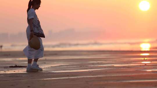 烟台夏天海边落日夕阳，女孩在沙滩上走动