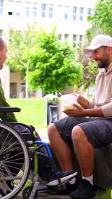 朋友在大学校园外喂一名残疾男子高清在线视频素材下载