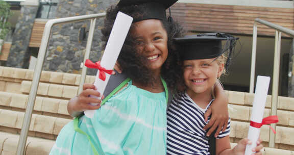 快乐的多样化女孩戴着毕业帽拿着文凭的视频