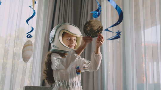 幻想儿童宇航员玩悬挂的宇宙行星