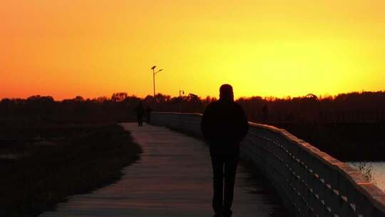 落日夕阳下湖边一个人走向夕阳升格慢镜