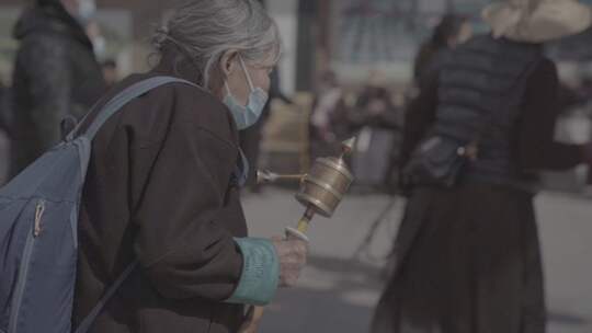 西藏老人拿着转经轮祈福特写慢镜头
