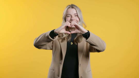 微笑的女商人展示形状心脏的标志积极的企业