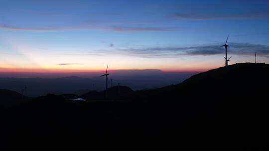 航拍夕阳下山顶风力发电机