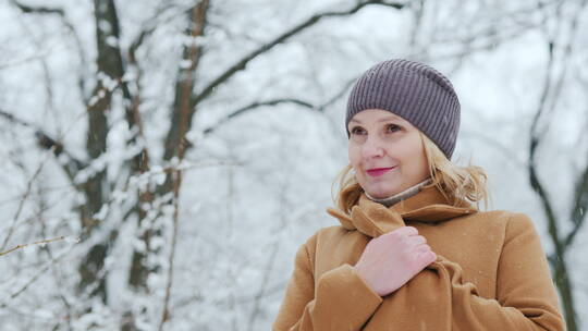 下雪天女人在公园里欣赏雪景