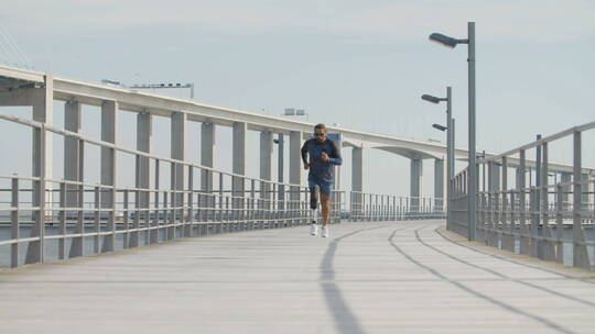 沿堤坝跑步的假肢男人