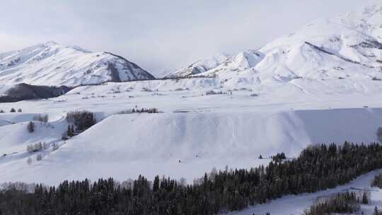 航拍新疆禾木雪景森林雪地小木屋禾木桥雪山