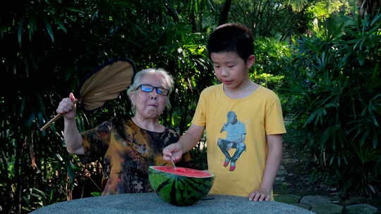 炎热夏天树下乘凉 老奶奶和孙子一起吃西瓜