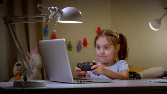 女孩用电脑和控制器玩电游戏视频素材模板下载