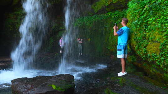 游客用手机拍瀑布的照片。剪辑。