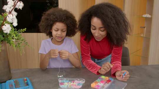 积极的母亲和黑色青春期女儿制作DIY儿童