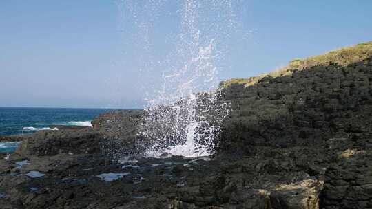 水从海上的岩石之间直接喷向空中