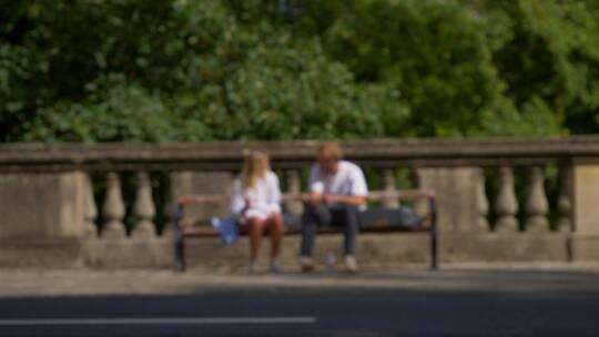 一对夫妇坐在街边长凳上