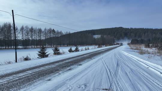 寒冷冬天行驶在冰雪道路上的汽车