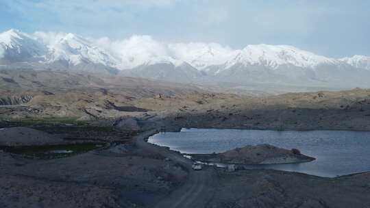 白色汽车行驶中昆仑山脚下崎岖的山路视频素材模板下载