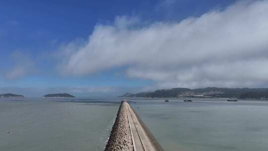 海边长堤与远处岛屿风景