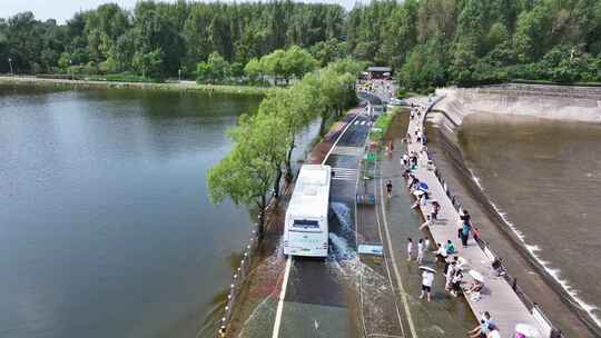 汽车从漫水路面开过航拍夏季净月潭公园