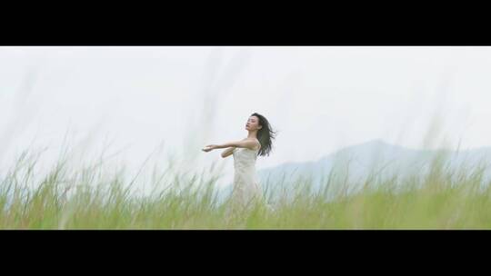 白色连衣裙女子在草地上跳舞