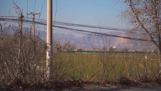 田野旁电线杆与远山风景