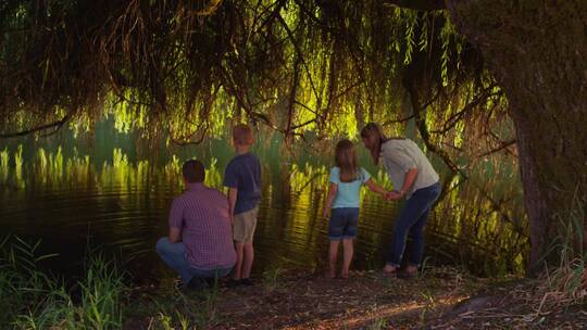 站在湖边看夜景的一家人