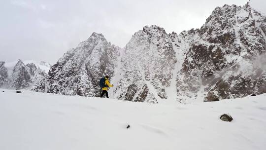 一名身穿黄色外套的男子在攀登山脊