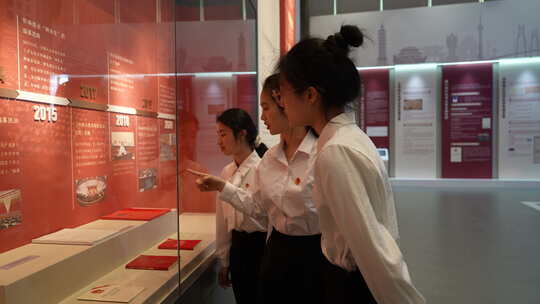 女生参观展览并指物交流