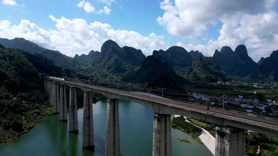 高铁动车列车高铁经过南方山谷上的湖面