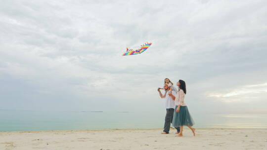 在沙滩上放风筝一家人