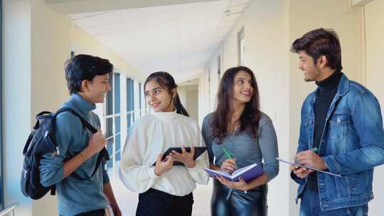 一群印度学生在大学里拿着书和平板电脑