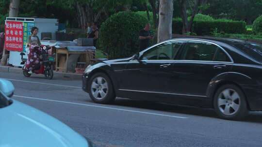 街道边电动车摊与行驶汽车