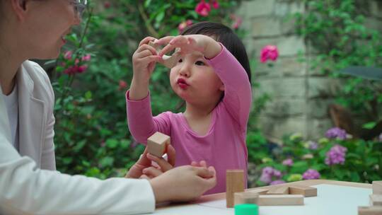小女孩和妈妈在院子里玩积木视频素材模板下载