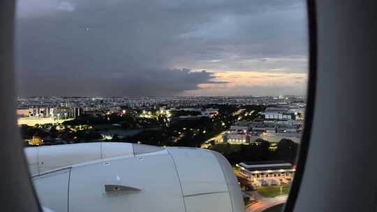 日落时分，新加坡城市建筑的飞机窗户鸟瞰，